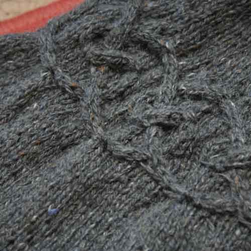 Horizontal cable motif with puckers extending above and below the cables.