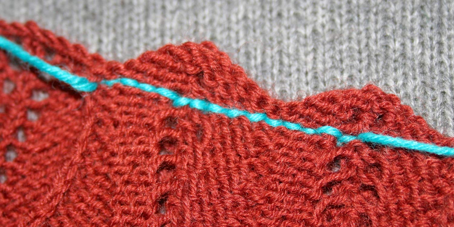 Wrong side of crochet seam showing short straight stitches in a contrasting colour all lined up one after another.
