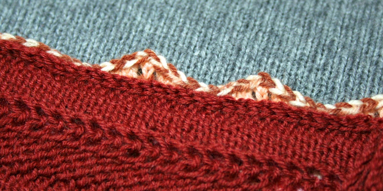 Wrong side of armhole seam showing edge of armhole with the top of the scalloped sleeve seam allowance popping up behind it.