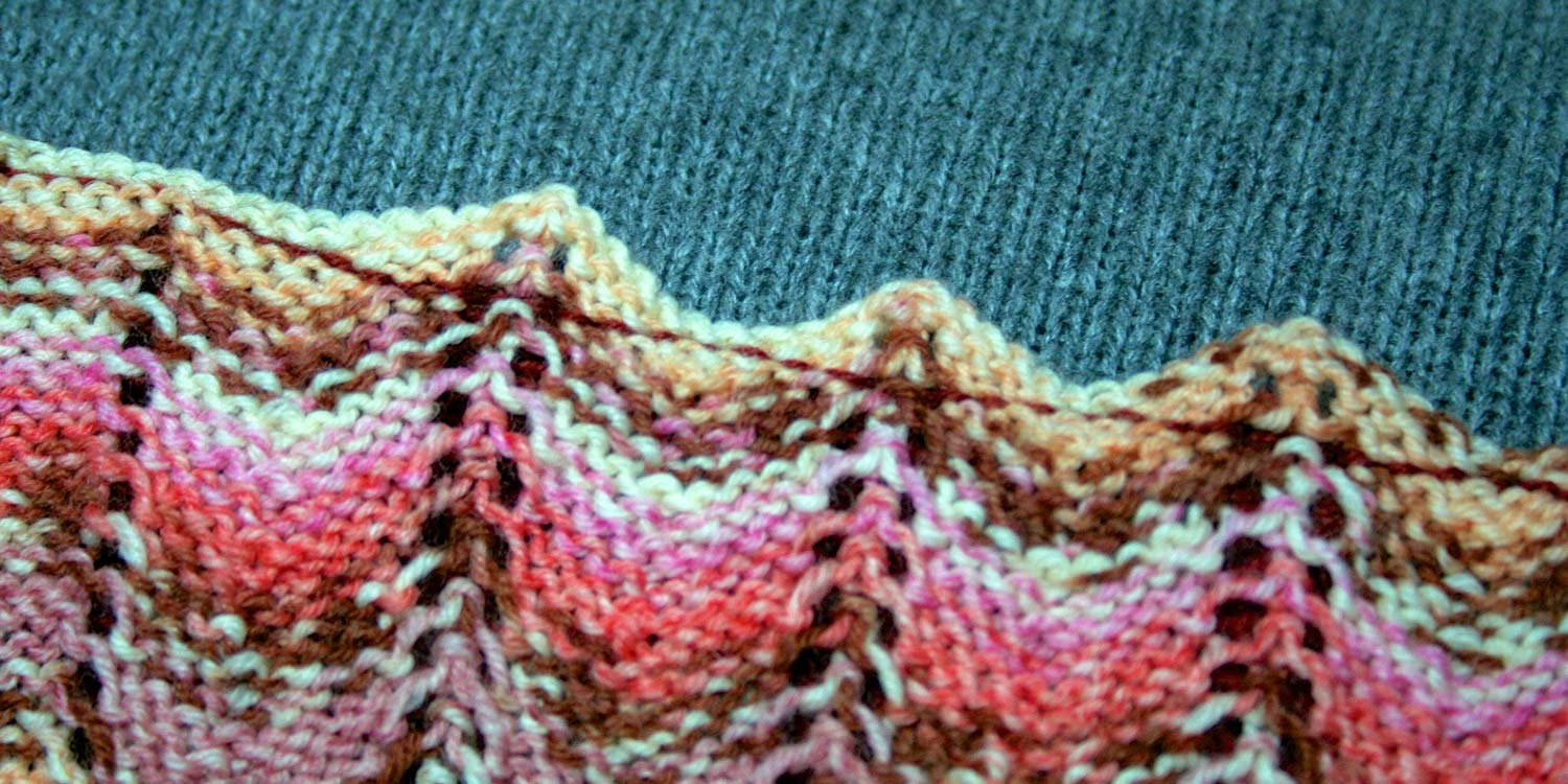 Armhole seam viewed from the other side showing just the scalloped sleeve top and the straight stitches created on the back side of the crocheted slip stitch seam.