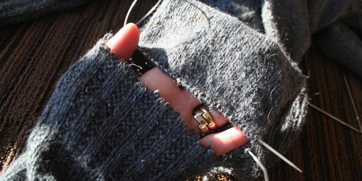 Hand slipped into a sweater cuff that's been separated from the rest of the sleeve; stitches on sleeve are safe on a circular needle.