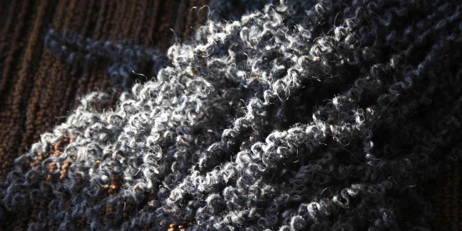 A pile of kinky, unravelled grey yarn.