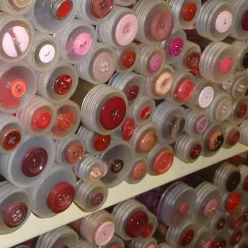 Shelf full of pink buttons in tubes.