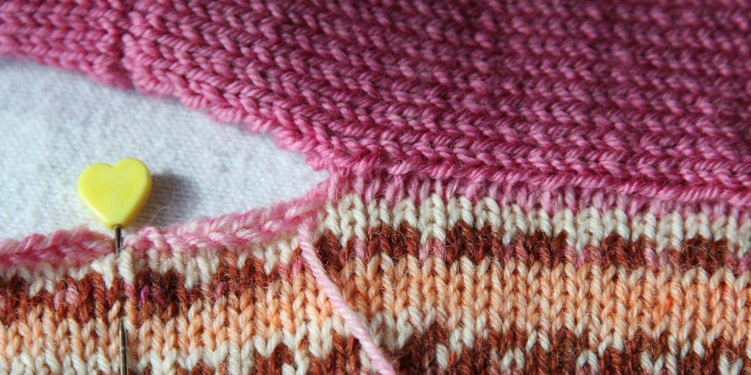 A partial seam has been sewn, joining the tops of stitches on one piece, to the sides of stitches on another piece.