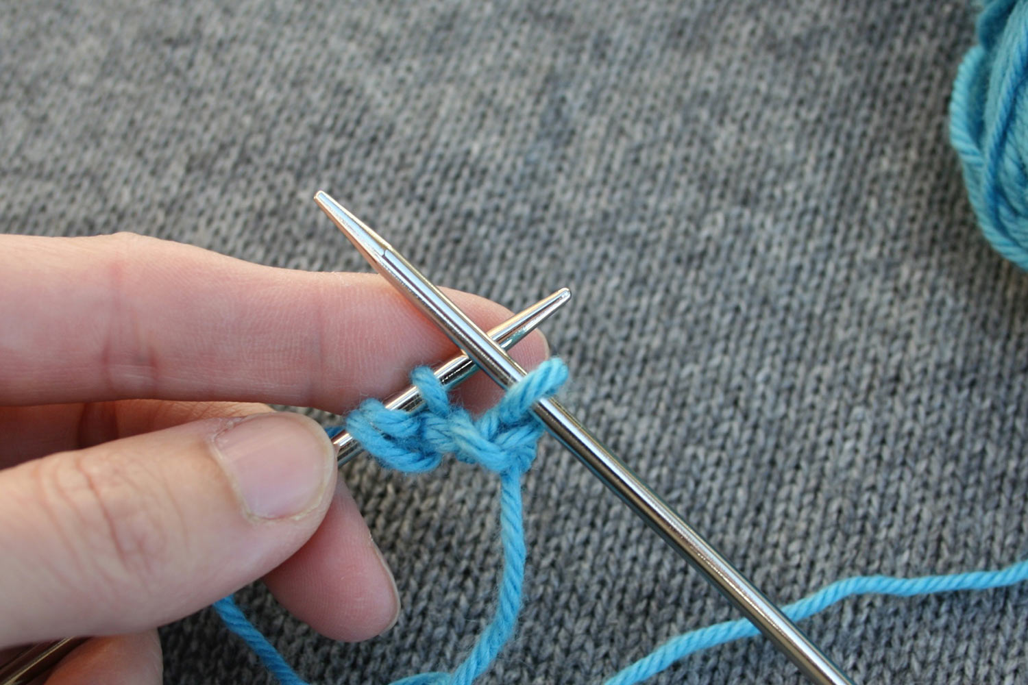 Right needle has one stitch after working a bind off; left needle has three stitches.