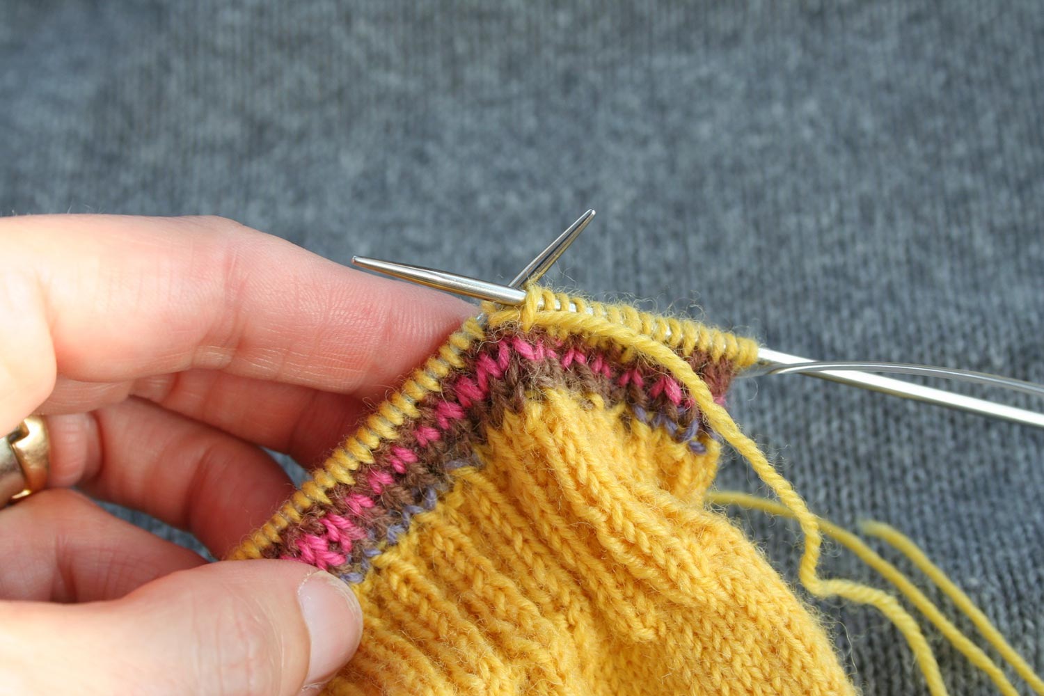 Knitting in the round with working yarn running through the first stitch on the left needle and then the last stitch on the right needle.
