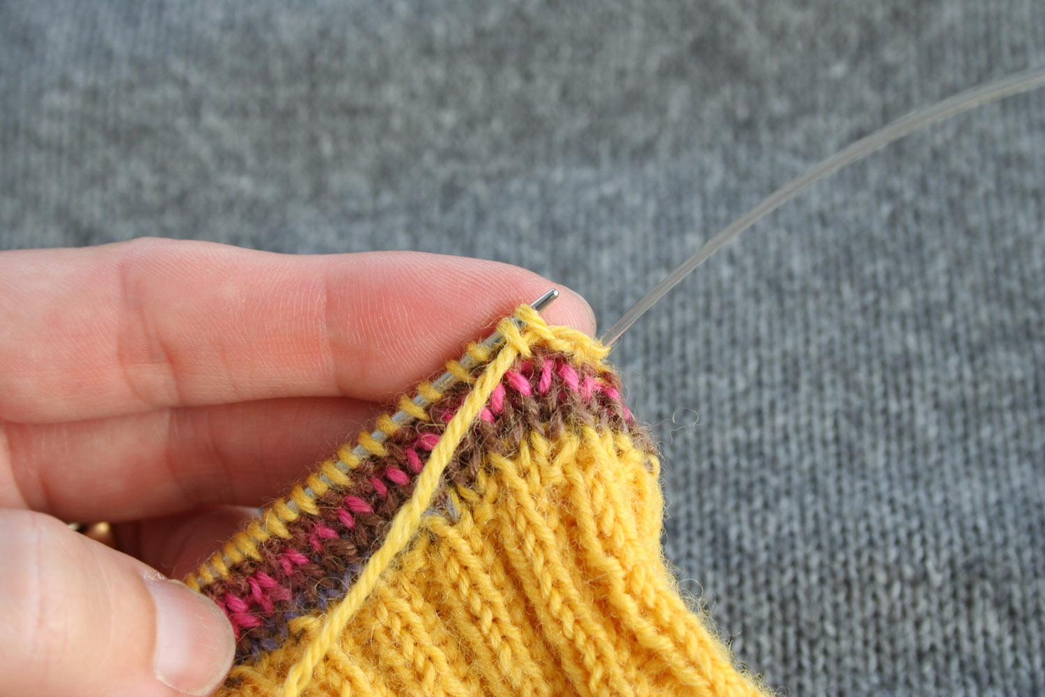 Yarn tail threaded through the first two stitches on the left needle.