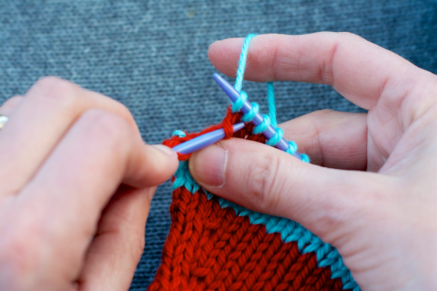 Tip of left knitting needle inserted into left leg of stitch, two rows below last stitch on right needle.