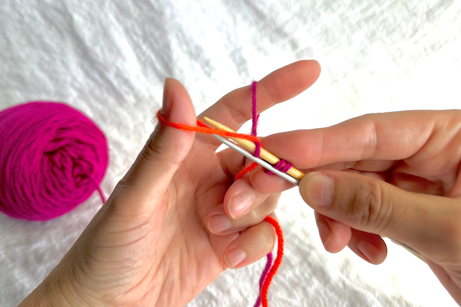 Both needles are inserted through thumb loop.