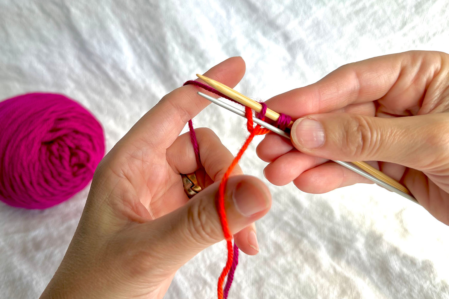 Thumb is returned to its regular location in thumb loop and lower part of cast on is tightening around smaller needle.