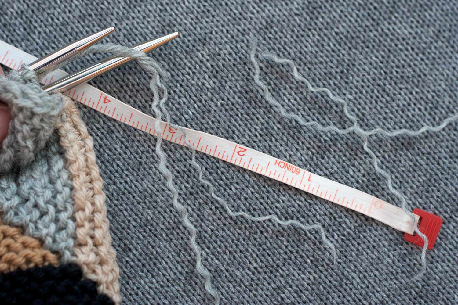 Tail of yarn has been unpaid and two of the plies have been torn from the tail; there's a measuring tape which indicates that the unpaid section is about 4".
