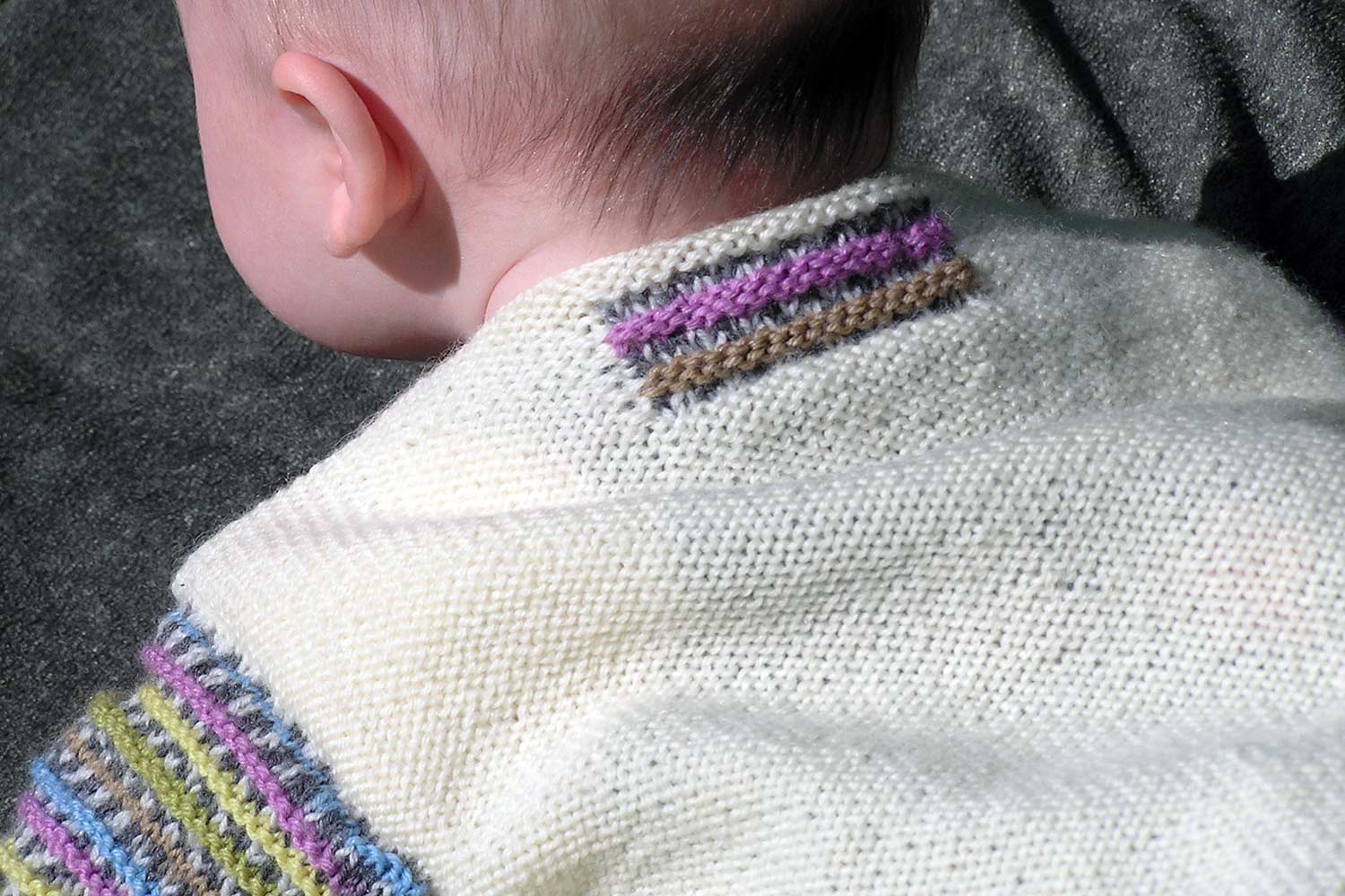 Detail of back of baby sweater with decorative rectangular motif just below neck.