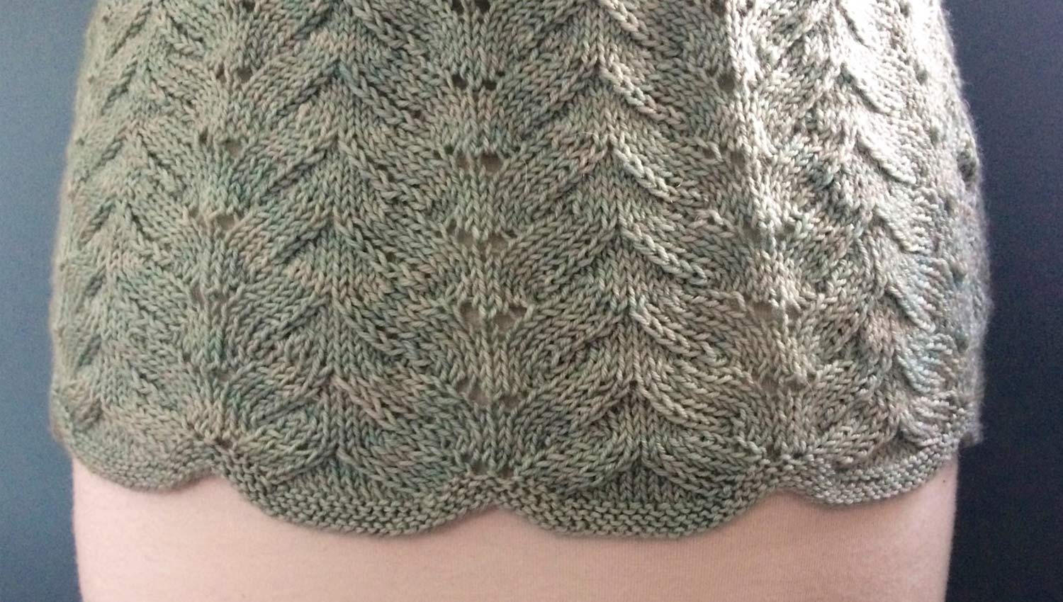 Detail of scalloped hem of lace side of top.