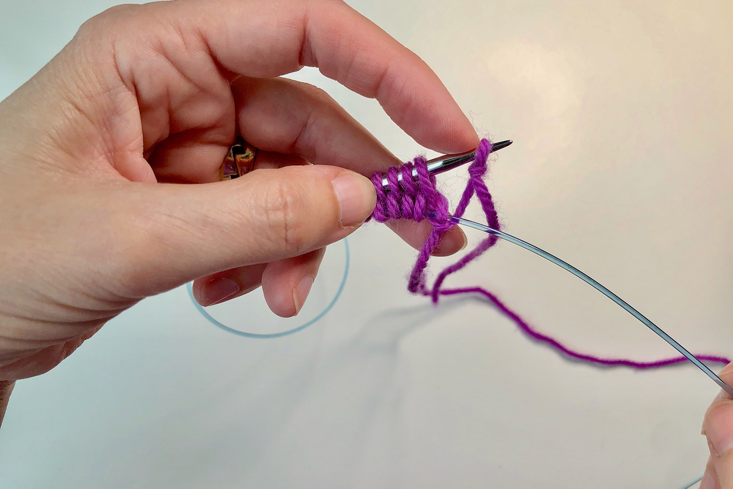 Half way through the Turkish cast on with stitches on the needle and a finger pushing a slip knot off the end of the needle.