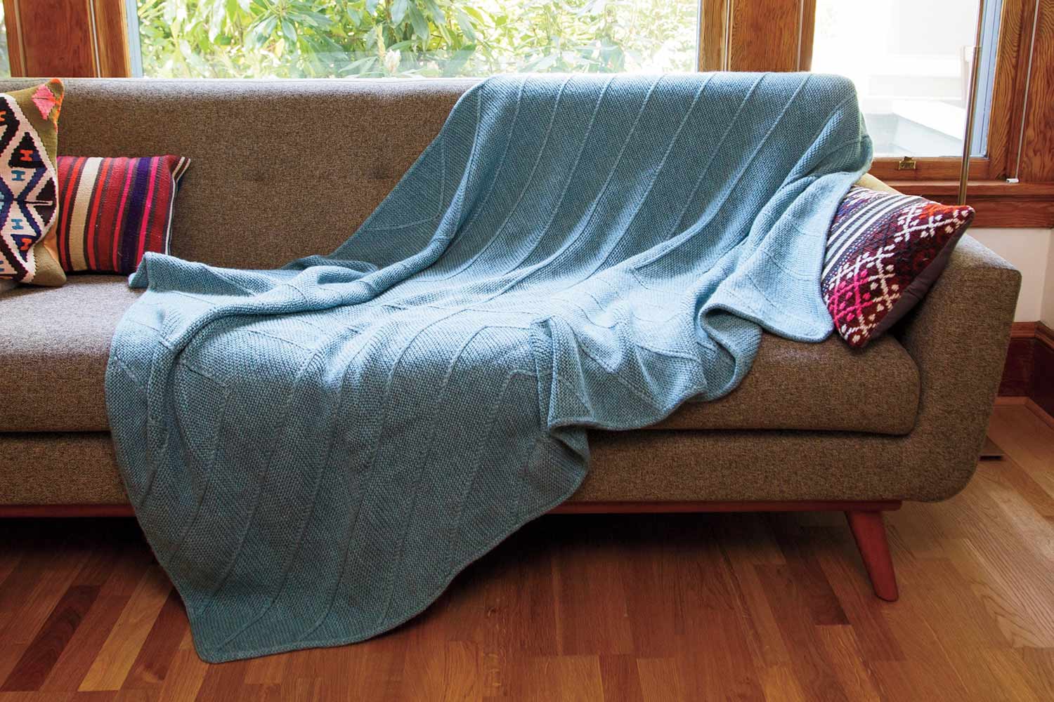 Blanket draped on couch.