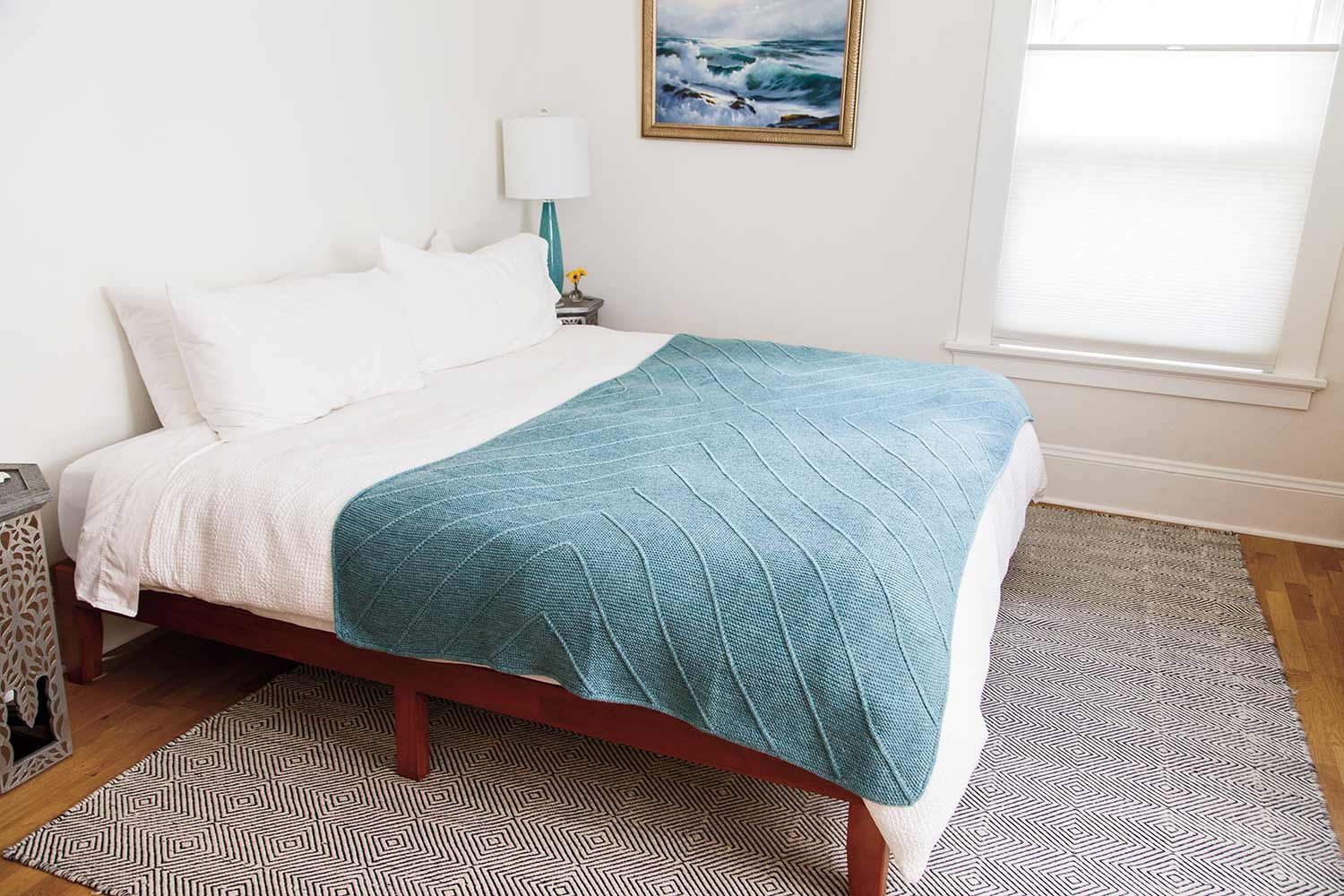 Blanket worked in modular knit strips creating a cross.