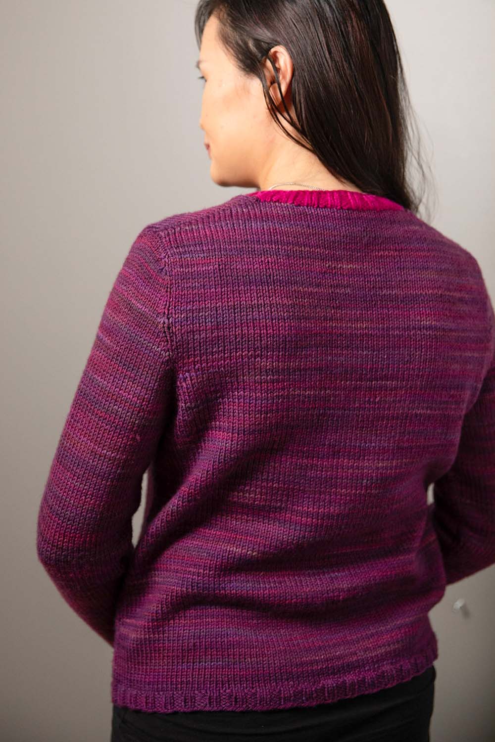 Back view of modeled cardigan showing inset sleeves and contrasting coloured neckband.