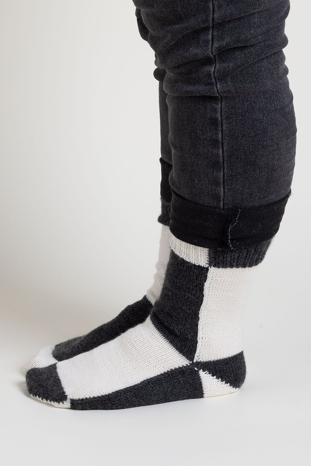 Side view of black and white colourblock socks worked flat; colour changes on each section of the sock.