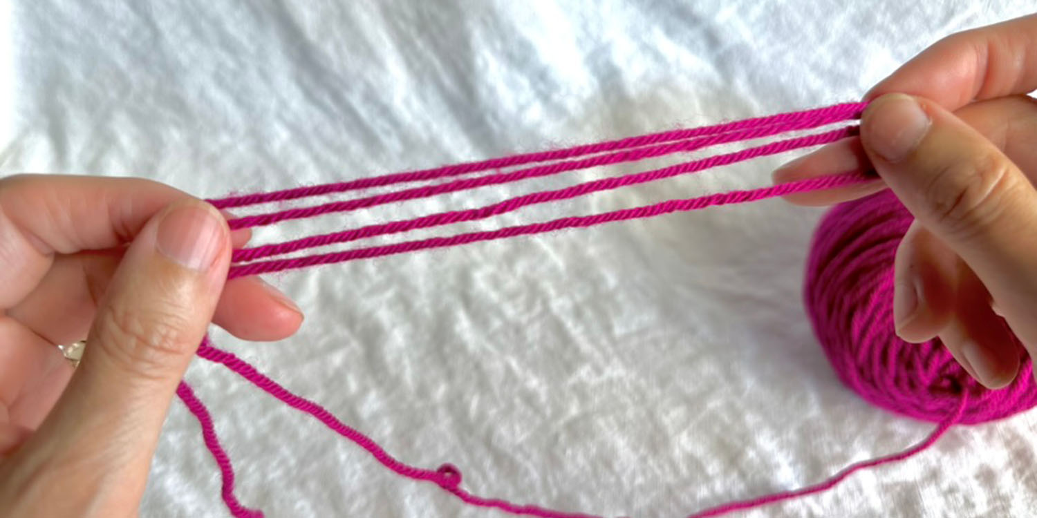 Length of yarn measured out by measuring out an initial length and folding extra yarn back and forth four times.