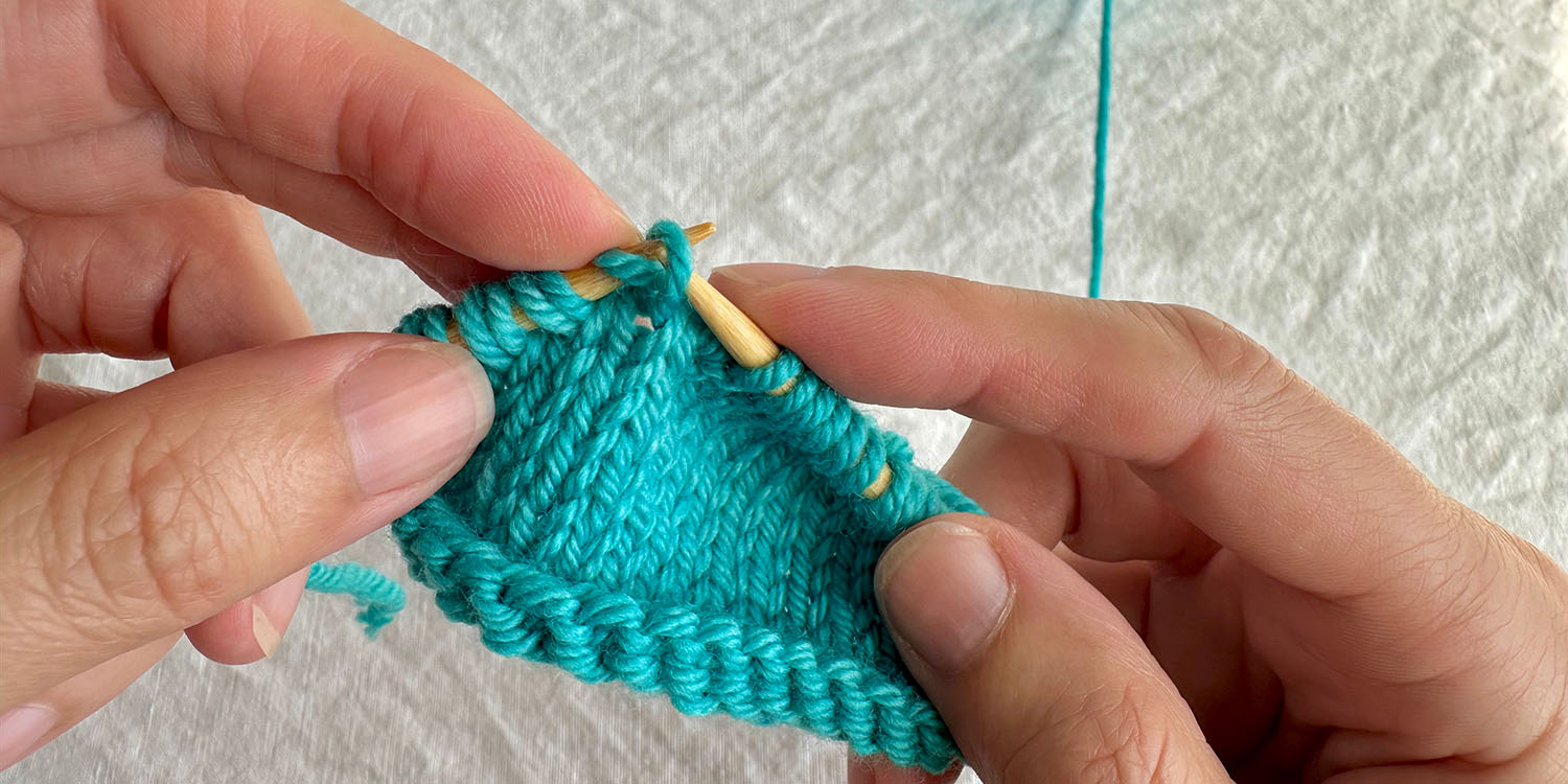 Stitch from row below is lifted up and placed on left needle as part of a raised increase.