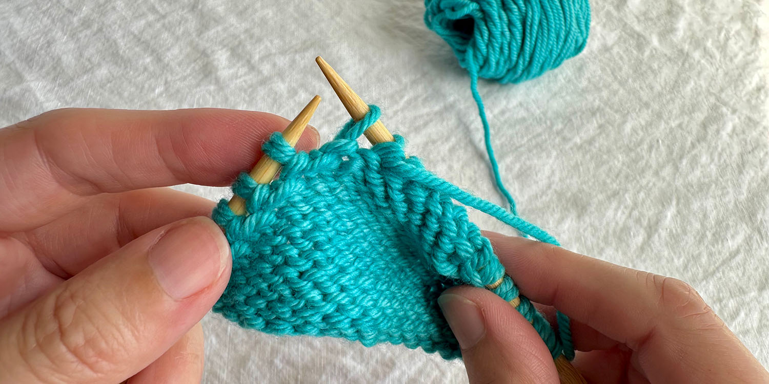 With wrong side facing, one stitch has been slipped to right needle, mid-row.