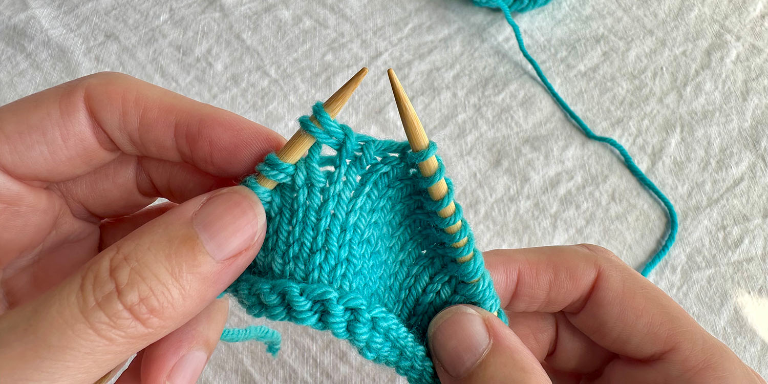 Looking at the easily identified twin stitches on left needle.