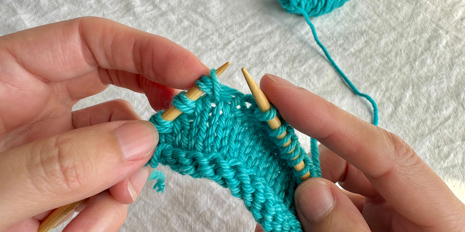 Stitch from row below is lifted up and placed on left needle as part of a raised increase.