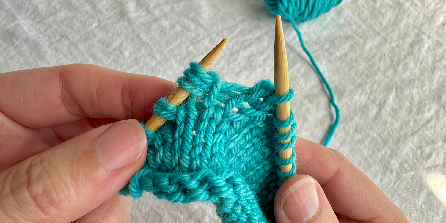 Triplet stitch on left needle is complete; it looks like three stitches coming out of one stitch in row below.