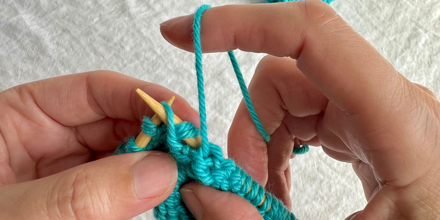 Right needle is inserted purlwise into raised stitch on left needle so it can be purled.