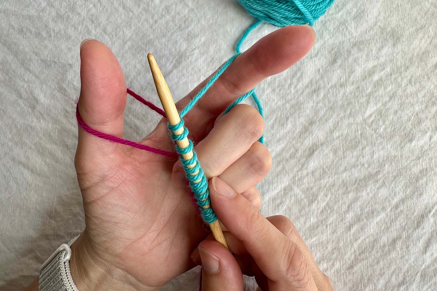 Slingshot hold with both thumb and finger loops in place and newly cast on stitches on needle.