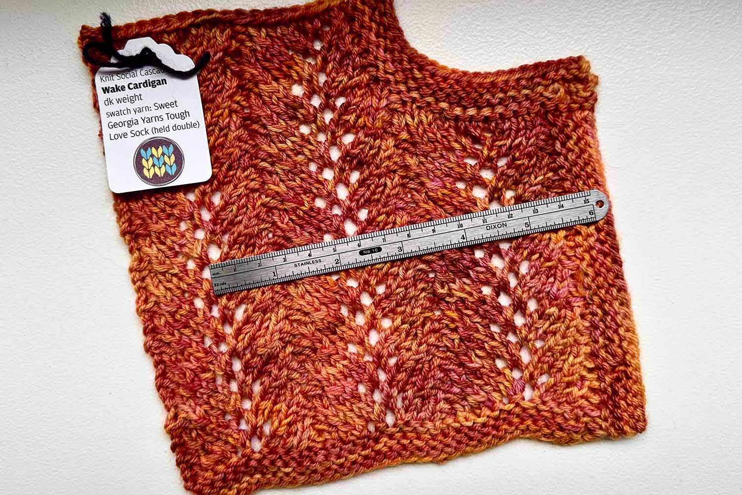 Lace swatch and ruler with label identifying it's for the Wake cardigan.