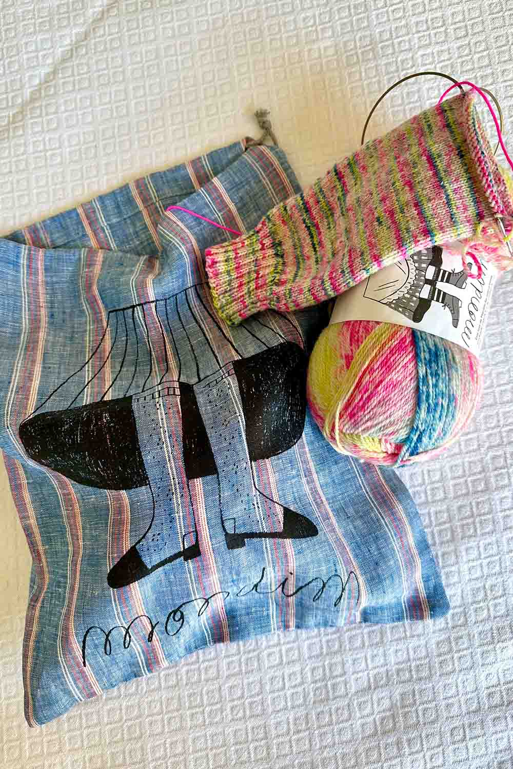Half knit sock with Modim sock yarn sitting on top of Modim project bag.